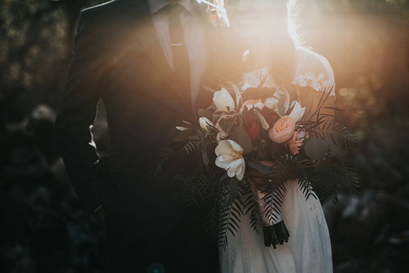 Cérémonie de mariage en extérieur avec arche fleurie et chaises blanches alignées.